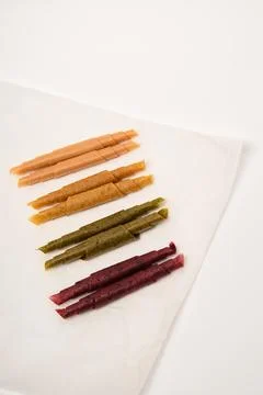 Pattern pastila fruit leather rolls up with fruits on white background. Vertical Stock Photos