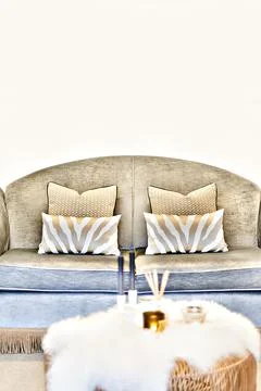 Pattern pillows on the sofa beside the blurred table Stock Photos