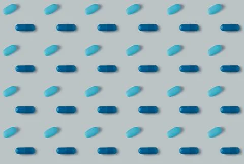 Pattern of pills on a blue background. Many pills on a light background Stock Photos