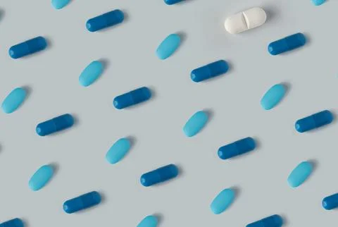 Pattern of pills on a blue background. Many pills on a light background Stock Photos