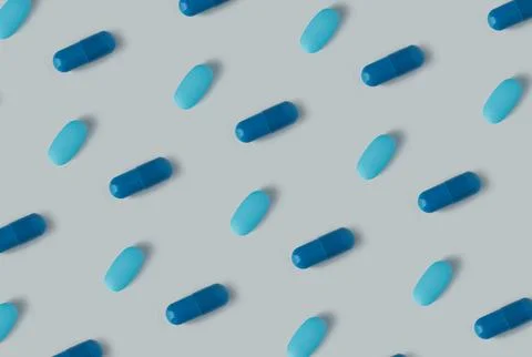Pattern of pills on a blue background. Many pills on a light background Stock Photos