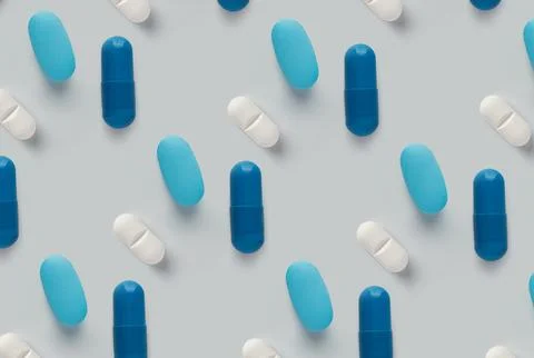 Pattern of pills on a blue background. Many pills on a light background Stock Photos