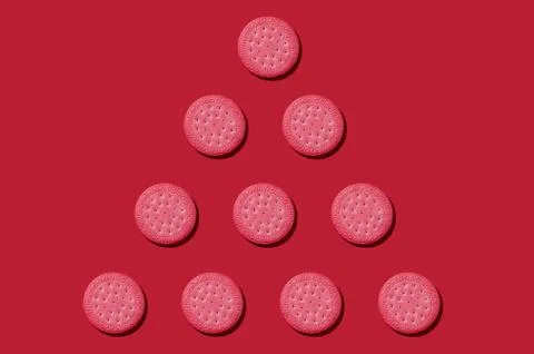 Pattern from pink biscuits on an red background. Abstract background Stock Photos