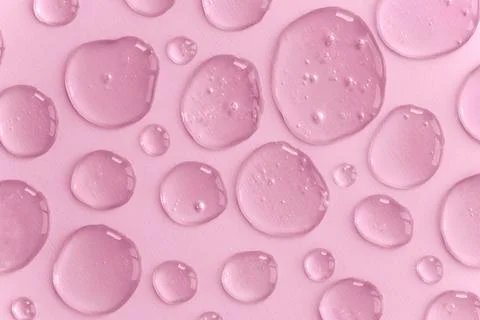 Pattern of pink colored doses of gel or serum on monochrome background. Abstract Foto stock
