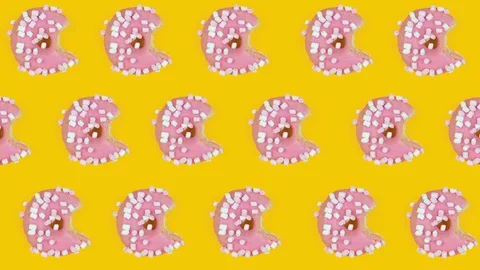 Pattern with pink donut, disappearing bite by bite. Creative concept stop motion Stock Footage 128923099