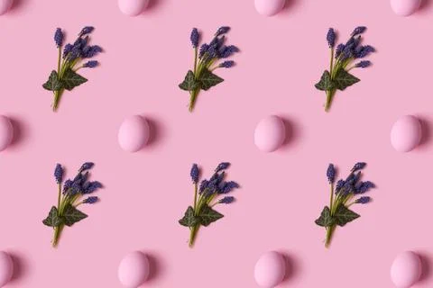 Pattern of pink Easter eggs and spring flovers over pink background Stock Photos
