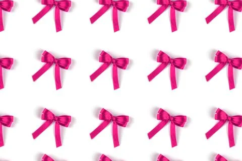 Pattern of pink silk gift bows isolated on white. Stock Photos