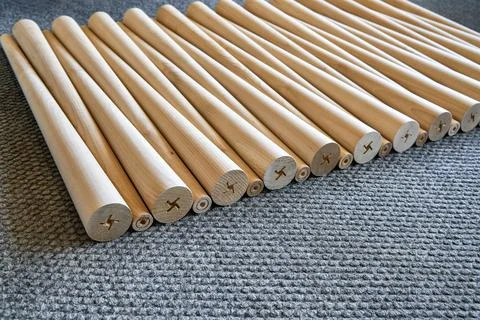 Pattern of polished conical wooden table legs on the gray carpet Stock Photos