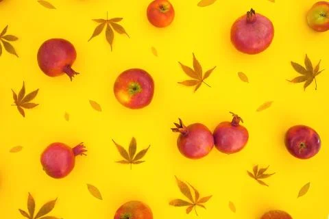 Pattern of pomegranate fuits with fall leaves isolated on yellow background.  Foto stock