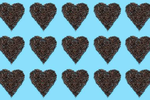 Pattern of pumpkin seeds in shape of hearts on blue background. Stock Photos