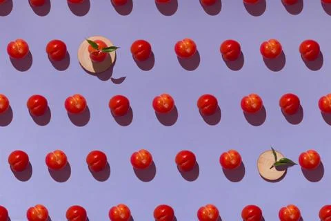 Pattern on a purple background with ripe red plums and wooden coasters Stock Photos