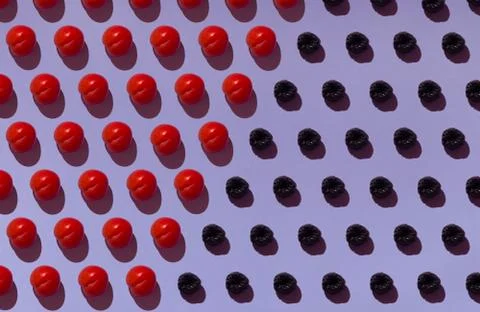 Pattern on a purple background with ripe red plums and wooden coasters Stock Photos