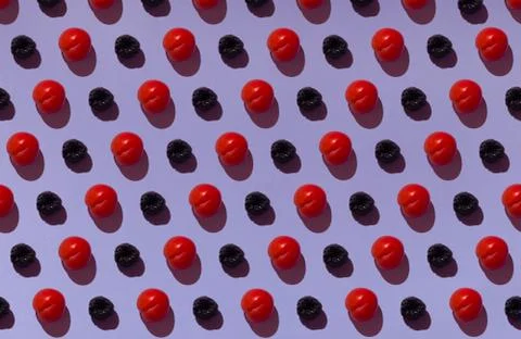 Pattern on a purple background with ripe red plums and wooden coasters Foto stock