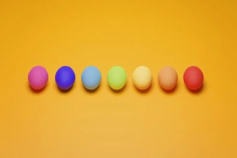 Pattern from rainbow chicken eggs on yellow background top view. Creative foo Stock Photos