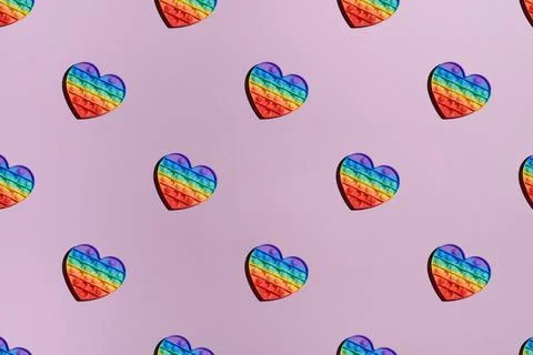 Pattern rainbow pop it fidget toy on pink background, top view Stock Photos