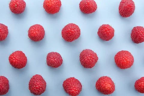 Pattern of raspberry on blue background. Flat lay summer berries - red raspbe Stock Photos