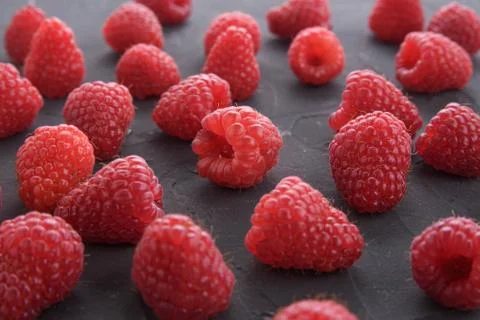 Pattern of raspberry on dark rock background. Flat lay summer berries - red r 写真素材