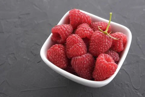 Pattern of raspberry on dark rock background. Flat lay summer berries - red r 스톡 사진