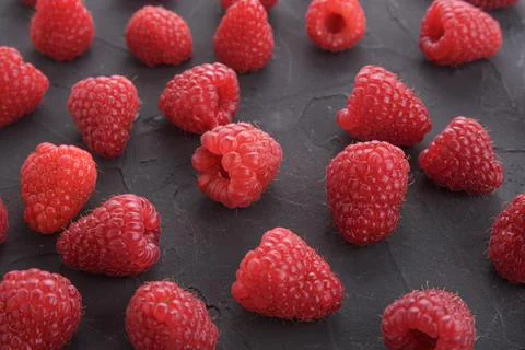 Pattern of raspberry on dark rock background. Flat lay summer berries - red r 스톡 사진