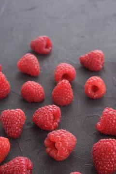 Pattern of raspberry on dark rock background. Flat lay summer berries - red r Stock Photos