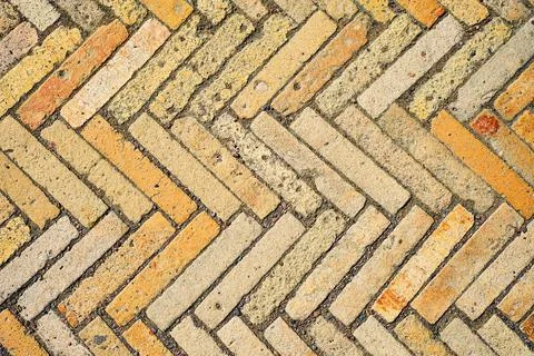 Pattern with rectangular yellow brick tiles in the form of a herringbone. Stock Photos