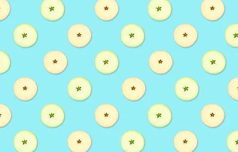 Pattern of red and green apple slices on light blue background Stock Photos
