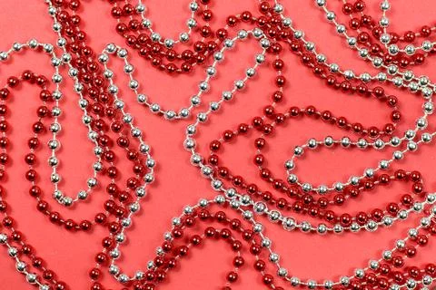 A pattern of red and silver beads for a Christmas tree on a red background Stock Photos