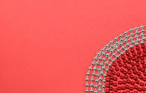 A pattern of red and silver beads for a Christmas tree on a red background Stock Photos