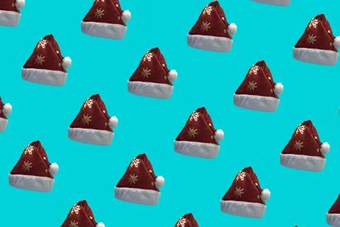 Pattern of Red and White Christmas Santa Claus Hat on a Blue Background. A .. Stock Photos