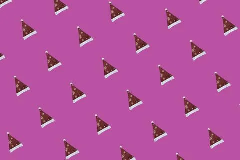 Pattern of Red and White Christmas Santa Claus Hat on a Pink Background. A .. Stock Photos