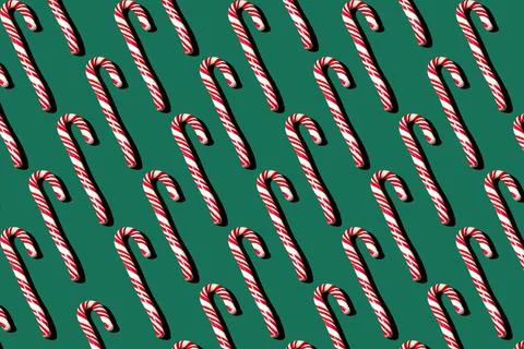 Pattern of red and white lollipops on a green background. Christmas concept Stock Photos