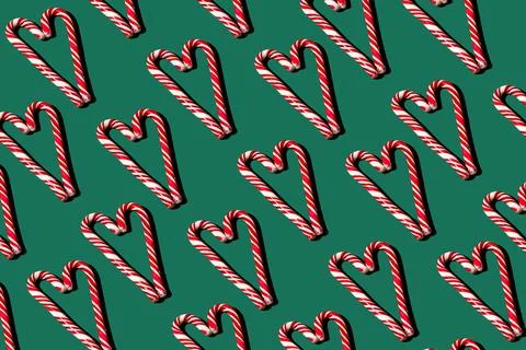 Pattern of red and white lollipops on a green background. Christmas concept Stock Photos