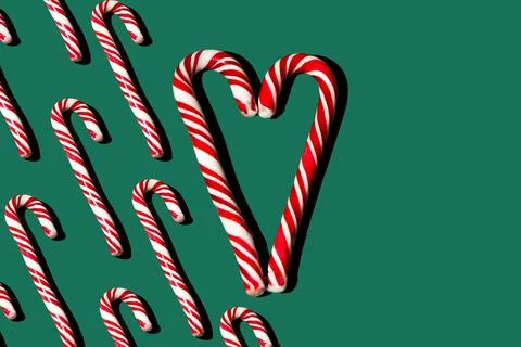 Pattern of red and white lollipops on a green background. Christmas concept Stock Photos