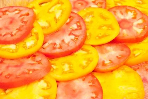 Pattern of red and yellow sliced tomatoes Stock Photos