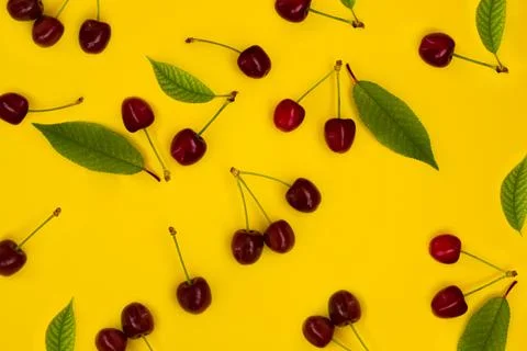 Pattern red cherries on a yellow background Stock Photos