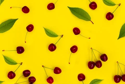 Pattern red cherries on a yellow background Stock Photos