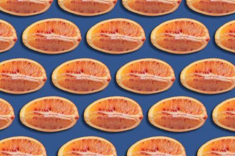 Pattern of red orange slices on blue background, citrus background Stock Photos