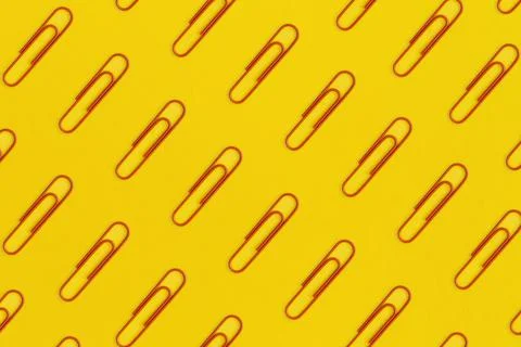 Pattern of red paper clips on yellow background. Top view. Flat lay. Back to Stock Photos