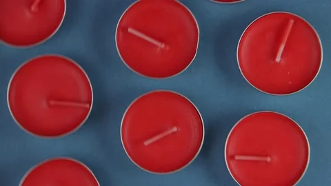 Pattern of red scented candles or tea candles close-up on a blue background on a Stock Footage 171244194