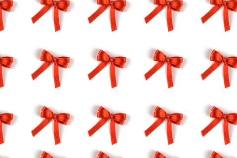 Pattern of red silk gift bows isolated on white. Stock Photos