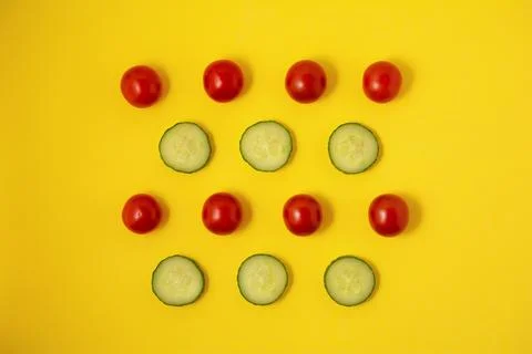Pattern red tomato and green cucumber on a yellow background Stock Photos