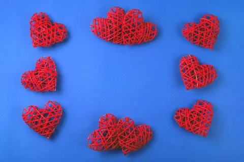 Pattern of the red wicker hearts on the cornflowerblue background. Stock Photos