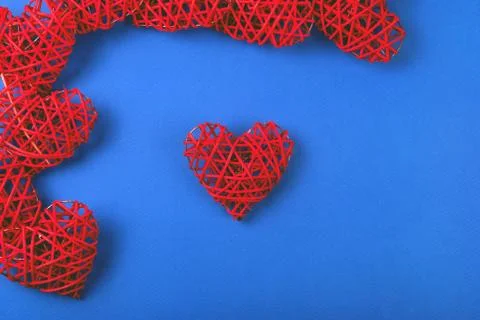 Pattern of the red wicker hearts on the cornflowerblue background. Stock Photos