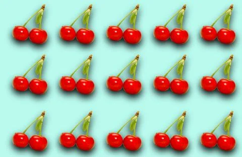 Pattern with ripe cherry berries on a turquoise background. Stock Photos
