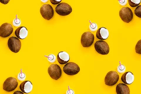 Pattern with ripe coconuts and bottle with drink on yellow background. Top View Foto stock