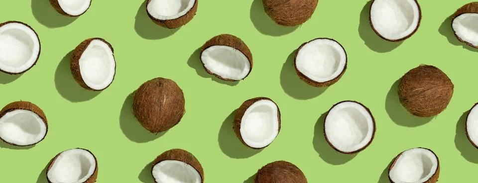 Pattern with ripe coconuts on green background. Top View Stock Photos