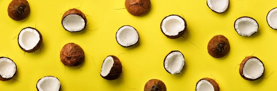 Pattern with ripe coconuts on yellow background. Top View. Copy Space. Pop art Stock Photos