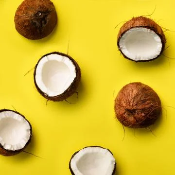 Pattern with ripe coconuts on yellow background. Top View. Copy Space. Square Stock Photos
