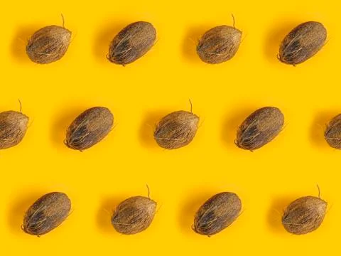 Pattern with ripe coconuts on yellow background. Top View. Copy Space. Pop ar Foto stock