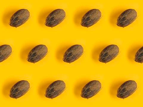 Pattern with ripe coconuts on yellow background. Top View. Copy Space. Pop ar Foto stock